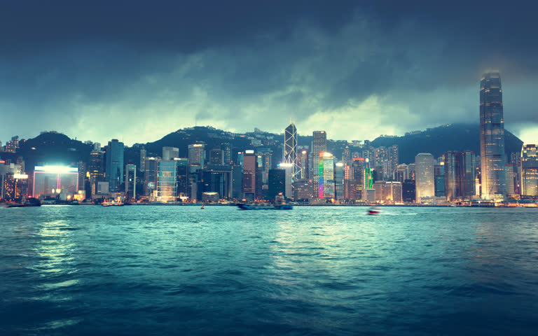 城市天际线的夜景,前景是一艘船