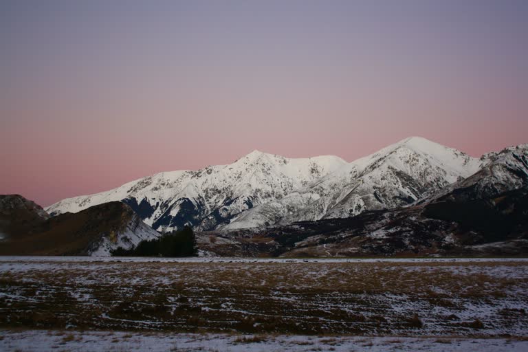 远处白雪皑皑的山峦,背景是粉红色的天空